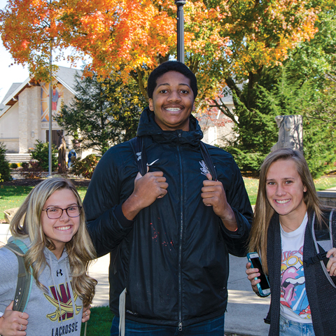 photo of three students on campus smiling