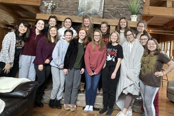 photo: Campus Ministry Sisterhood group gathered in front of a fireplace