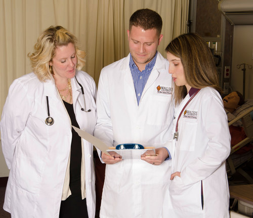 photo of three graduate nursing students having a discussion in a hospital room