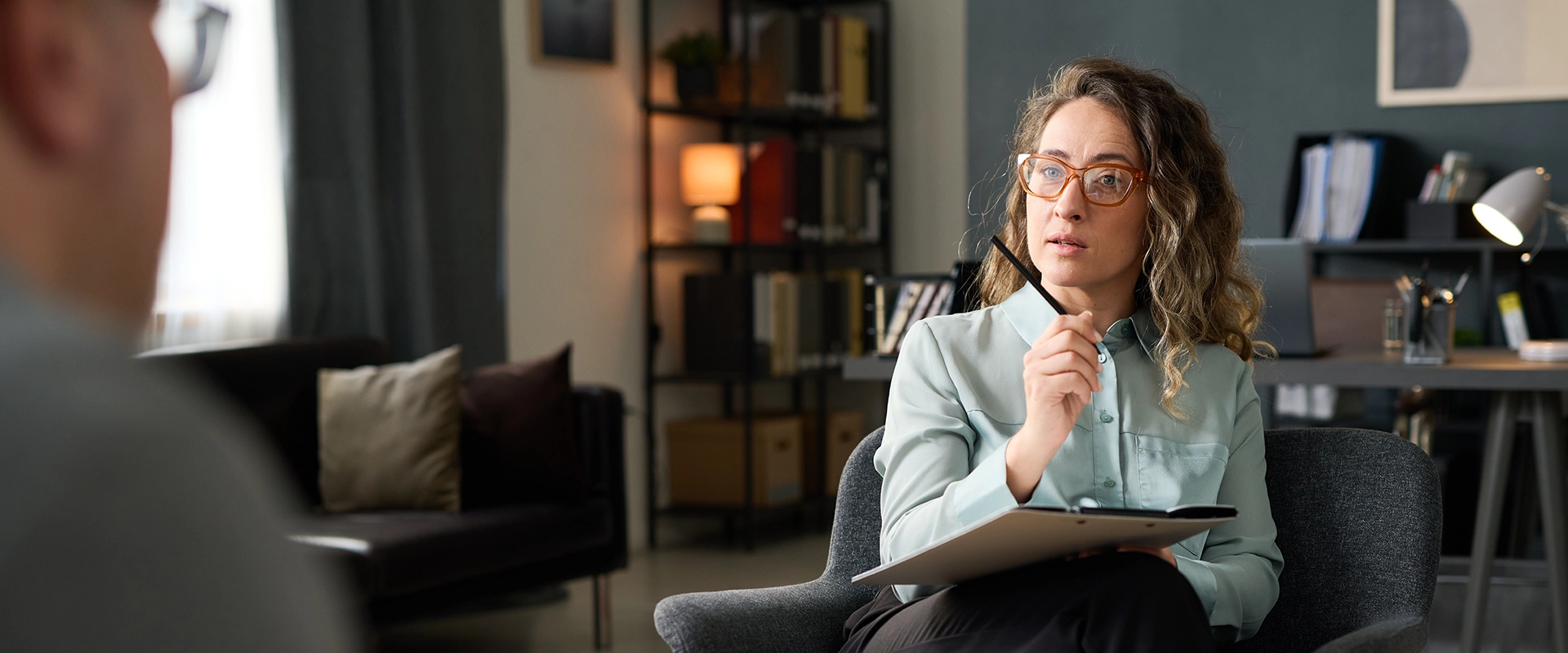 Counseling professional engaged in a one-on-one session with a client in a welcoming office setting.