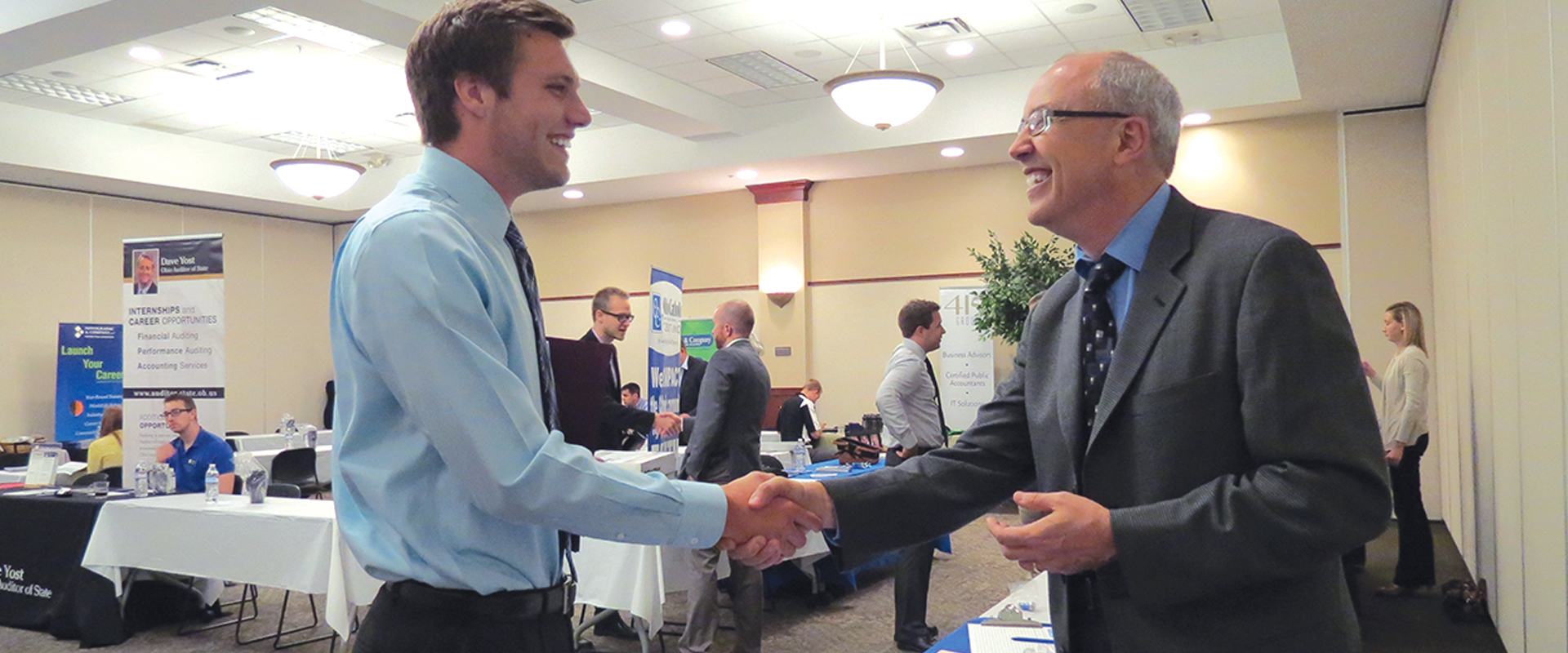 photo of student shaking hands with a company representative at a career fair