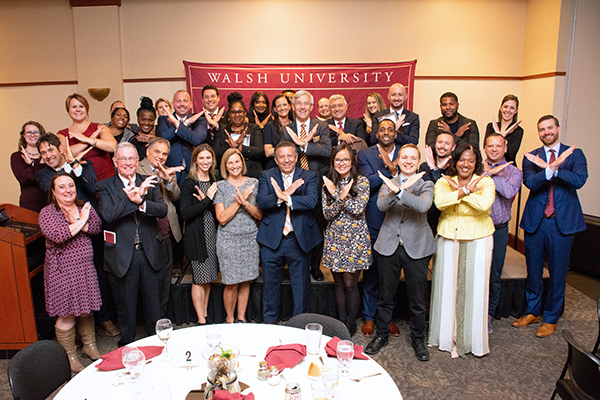 Group shot of Alumni with Swords Up hand gesture