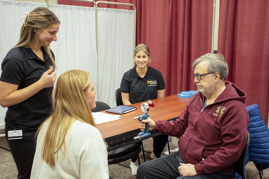 Healthcare professionals conducting a patient assessment with a medical device in a consultation setting.