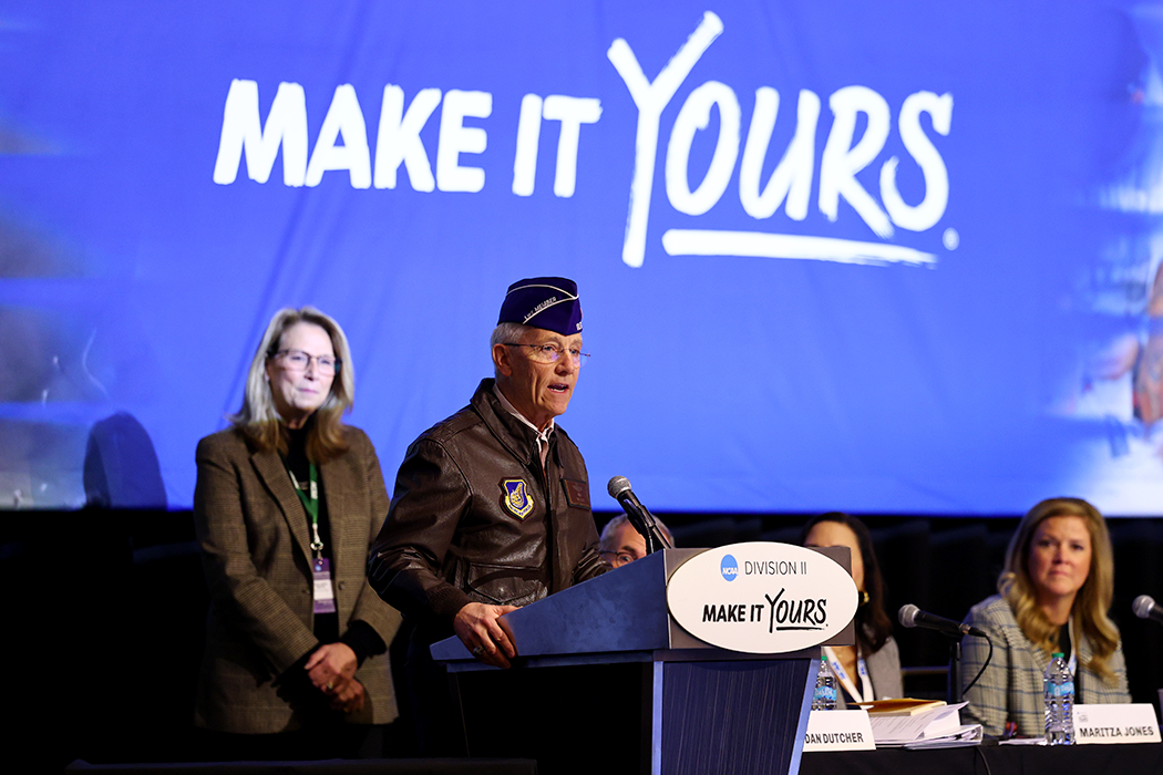 Walsh University President Tim Collins speaking from behind a podium while accepting the NCAA DII Award of Excellence in Athletics.