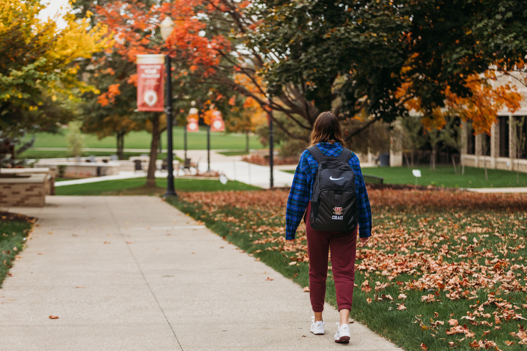 Photo of student walking on campus in fall